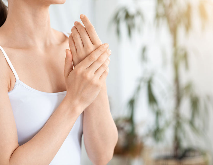 woman putting on CBD pain relief cream on her hands